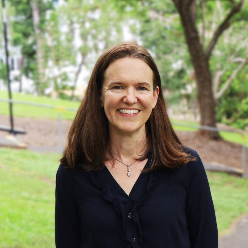 Studio Management Annette Blakeney smiling in Roma Street Parkland in black blouse.