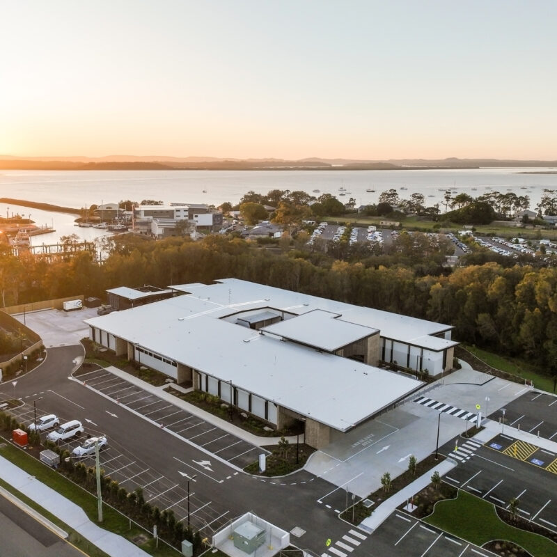 Redlands Satellite Hospital at sunrise with the bay clearly visible and a reflection on the water.